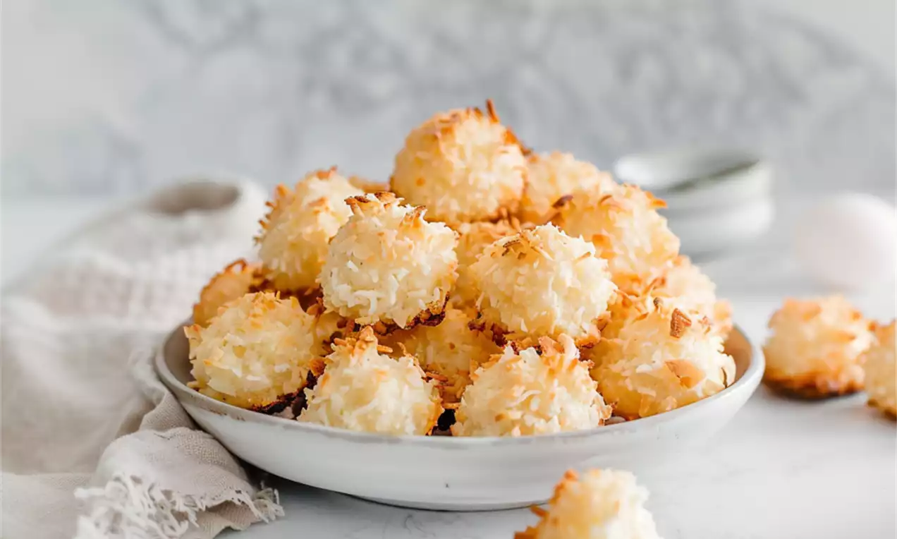Rochers dorés légèrement croustillants et moelleux à la noix de coco, en forme de petits dômes sur une assiette blanche